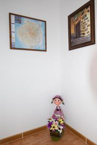 因赫尼奥Villa Florymar的一张娃娃坐在地板上,墙上挂着两张照片