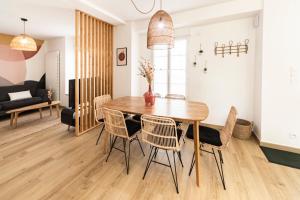 塞夫勒河畔圣洛朗Le Clos de la Jouvence - Gite 4* à 15 minutes du Puy du Fou, 6 personnes的用餐室以及带木桌和椅子的客厅。