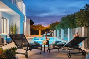 普拉Monvidal Residence - Adults Only的游泳池畔的两把椅子和一张桌子