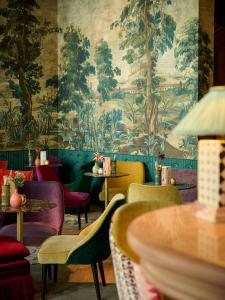 科特赖克达米耶科特克酒店的餐厅配有色彩缤纷的椅子和壁纸