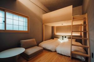 吴市無垢　入船の宿的一间卧室配有双层床和椅子
