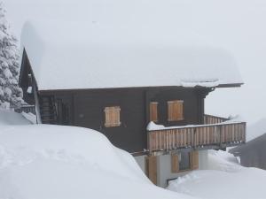 利德阿尔卑斯Apartment Jonathan Parterre by Interhome的雪覆盖的房屋,有甲板