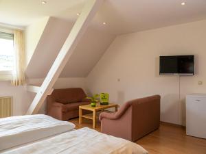 于尔齐希盖拉赫葡萄酒庄/酒店的卧室配有一张床,墙上配有电视。