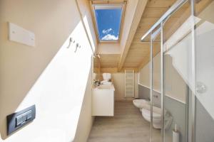 泰塞罗CASA PARE' B&B的一间带两个卫生间的浴室和天花板上的窗户