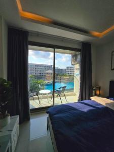 乔木提恩海滩Laguna beach condo resort 3 maldives pattaya top pool view ลากูน่า บีช คอนโด รีสอร์ต 3 พัทยา的一间卧室设有一张床,享有阳台的景色