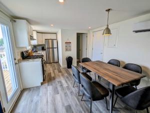 LanarkNewly Renovated 3 Bedroom Beach Front Condo 1B的厨房以及带木桌和椅子的用餐室。
