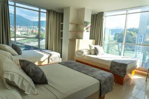 麦德林Hotel Alcaravan Medellín的酒店客房设有两张床和大窗户。