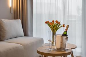 StaniszówTermy Karkonosze Resort & Spa的客厅配有桌子、一瓶香槟和鲜花