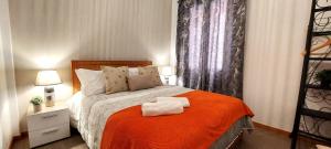 丰沙尔Vista City的一间卧室配有一张带橙色毯子的床