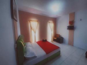 秾莎BOTANIA HOMESTAY BATAM的一间卧室配有一张带红色毯子的床和两个窗户。