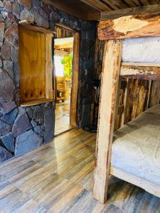 维库尼亚Cabañas Rusticas Olimpus del Elqui的一间卧室设有一张床和石墙