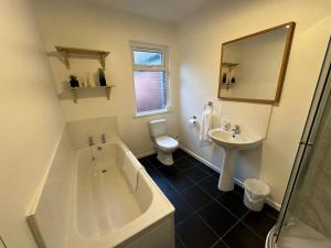 贝尔法斯特2br Stylish Ormeau Road House的带浴缸、卫生间和盥洗盆的浴室