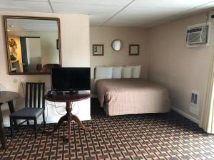 埃尔斯沃思Colonial Inn Ellsworth的酒店客房配有一张床和一张带电脑的书桌
