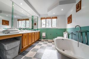 CantleyChalet Mont Cascades w/ Spa & Fibre Optic Internet的带浴缸、两个盥洗盆和浴缸的浴室。