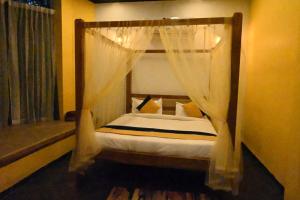 塔拉Olive的一间卧室设有天蓬床和窗户。