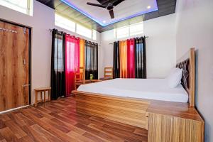 奈尼塔尔Super OYO Sadhna Holiday Home的一间卧室配有一张床,铺有木地板