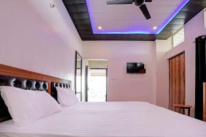 奈尼塔尔Super OYO Sadhna Holiday Home的卧室配有白色床和蓝色天花板