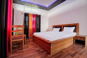 奈尼塔尔Super OYO Sadhna Holiday Home的一间卧室配有一张床,铺有木地板