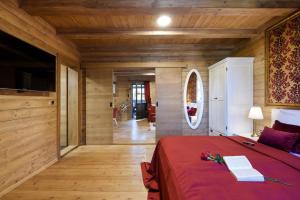 普利特维采湖Lakeside Hotel Plitvice的一间卧室设有红色的床和木墙