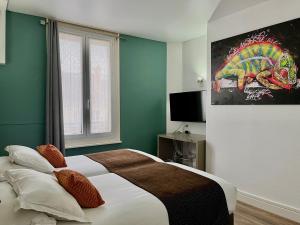 香槟沙隆HOTEL & SPA Le Renard Centre的卧室配有一张床,墙上挂有绘画作品