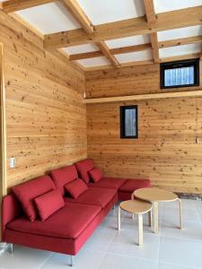 嬬恋村Kita Karuizawa Morino Takibi NO7 Sauna Sweet的配有木墙的客房内的红色沙发