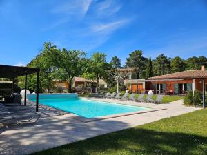 鲁西永Les Sables d'Ocre & SPA的一个带躺椅的游泳池以及一座房子
