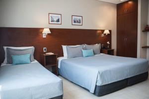 科连特斯DonSuites的两张位于酒店客房的床,配有蓝色枕头