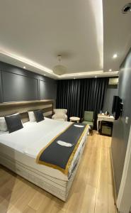 伊斯坦布尔Florya House Hotel的一间卧室配有一张大床和一张书桌
