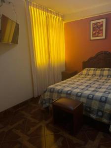 塔克纳HOTEL ARC&SUITE的一间卧室配有床和黄色窗帘