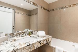 圣安妮·道雷Logis L'Auberge - Maison Glenn Anna的一间带大理石盥洗盆和浴缸的浴室