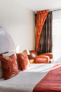圣安妮·道雷Logis L'Auberge - Maison Glenn Anna的酒店的客房 - 带枕头和椅子的床