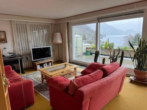 韦吉斯Charming Apartment w/Terrace on Lake and Mountain的客厅设有红色的沙发和大窗户