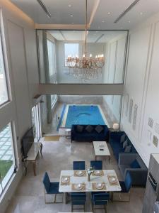 阿可贺巴شاليه رويال الخبر - Royal Resort AL Khobar的游泳池位于带桌椅的房间中间