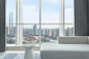 广州Sheraton Guangzhou Hotel的客厅配有白色沙发和大窗户