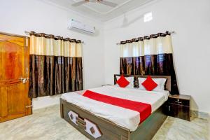 布巴内什瓦尔Super OYO Flagship Namaskar Cozzy Cottage的一间卧室配有床和带窗帘的窗户