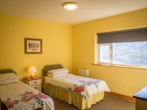 伦维尔Lough Fee Renvyle的黄色客房 - 带两张床和窗户