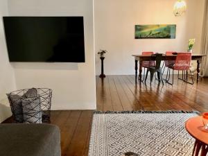 杜伊斯堡Apartments "Am Rheinorange", Netflix, Amazon Prime的客厅设有一张带红色椅子的餐桌