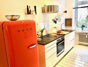 杜伊斯堡Apartments "Am Rheinorange", Netflix, Amazon Prime的厨房配有橙色冰箱