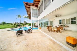 拉罗马纳Casa de Campo Elegance - 8-Bedroom Golf View Villa的一个带桌椅的室内庭院和一个游泳池