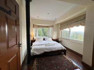 穆里Sarah's Lodge的一间卧室设有一张床和一个大窗户