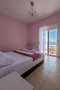 萨兰达Noel Sea View Apartments的一间带两张床的卧室,享有海景