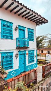 杰里科Villa Linda ApartaHotel的一栋带蓝色窗户和围栏的建筑