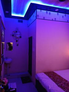 Ayodhyaसुभद्रा guest house的紫色的客房配有一张床和一个水槽