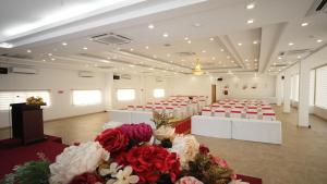 Bạc LiêuSÀI GÒN - BẠC LIÊU Hotel的宴会厅配有红色和白色的桌椅