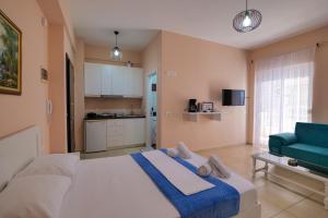 萨兰达Noel Sea View Apartments的一间卧室配有一张大床和一张蓝色的沙发
