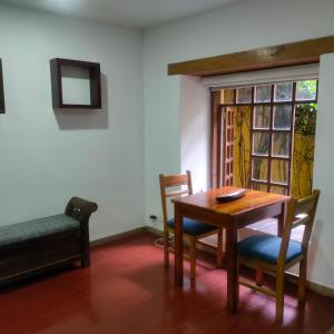 波哥大拉坎德拉里亚公寓式酒店的一间带桌椅和窗户的用餐室