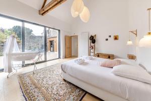 拉瓦勒La Familia - Maison chaleureuse的白色的卧室设有床和大窗户
