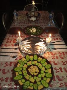 Mandīshahoasis panorama的一张桌子,上面放着蜡烛,上面放着食物