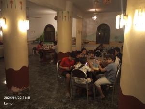 Mandīshahoasis panorama的一群坐在餐厅桌子上的人