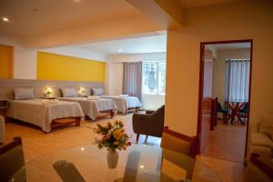 塔克纳HOTEL SUDAMERICANA INN的酒店客房带两张床和一个客厅